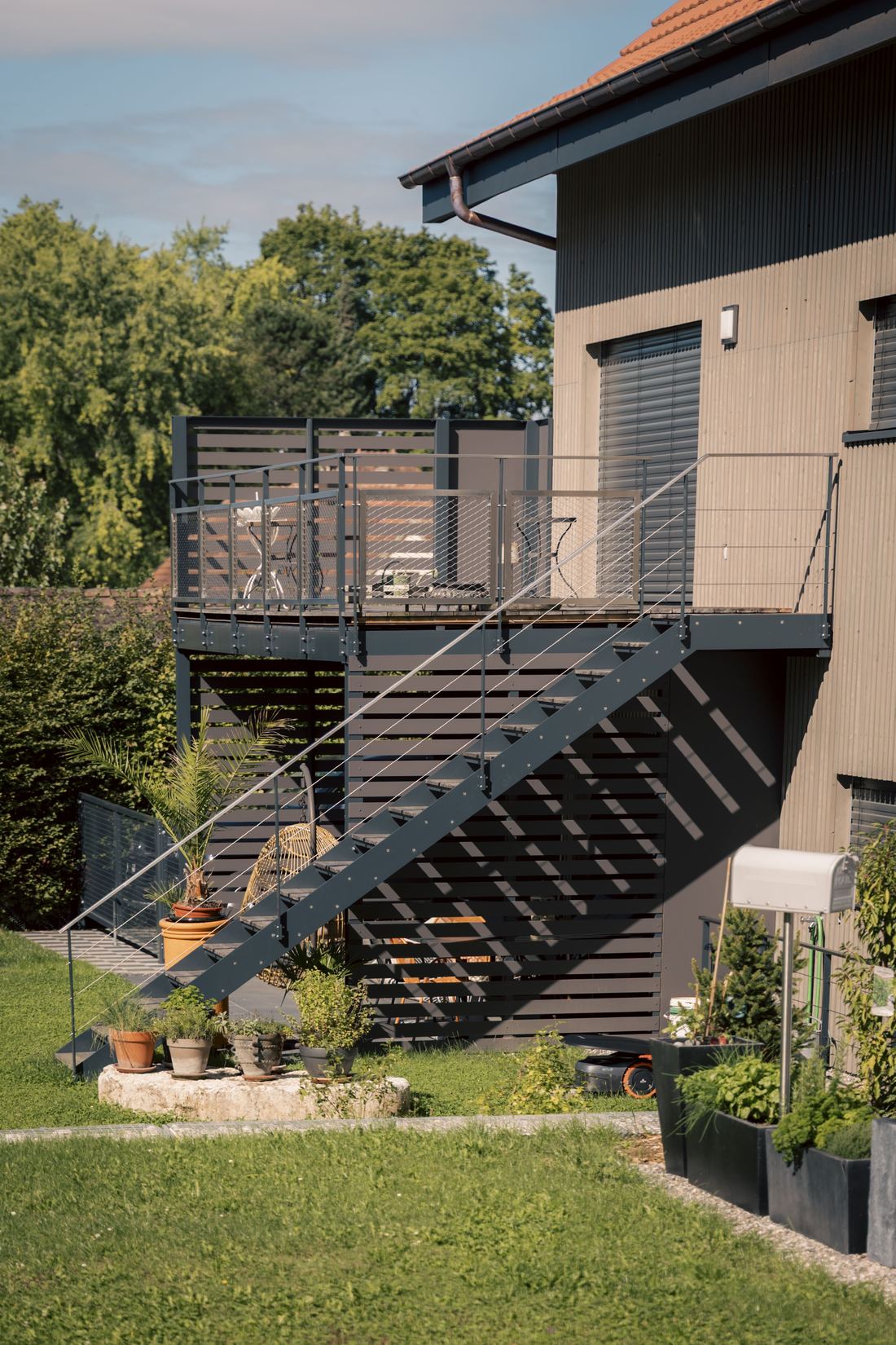 Escalier extérieur métallique et balcon sur une maison