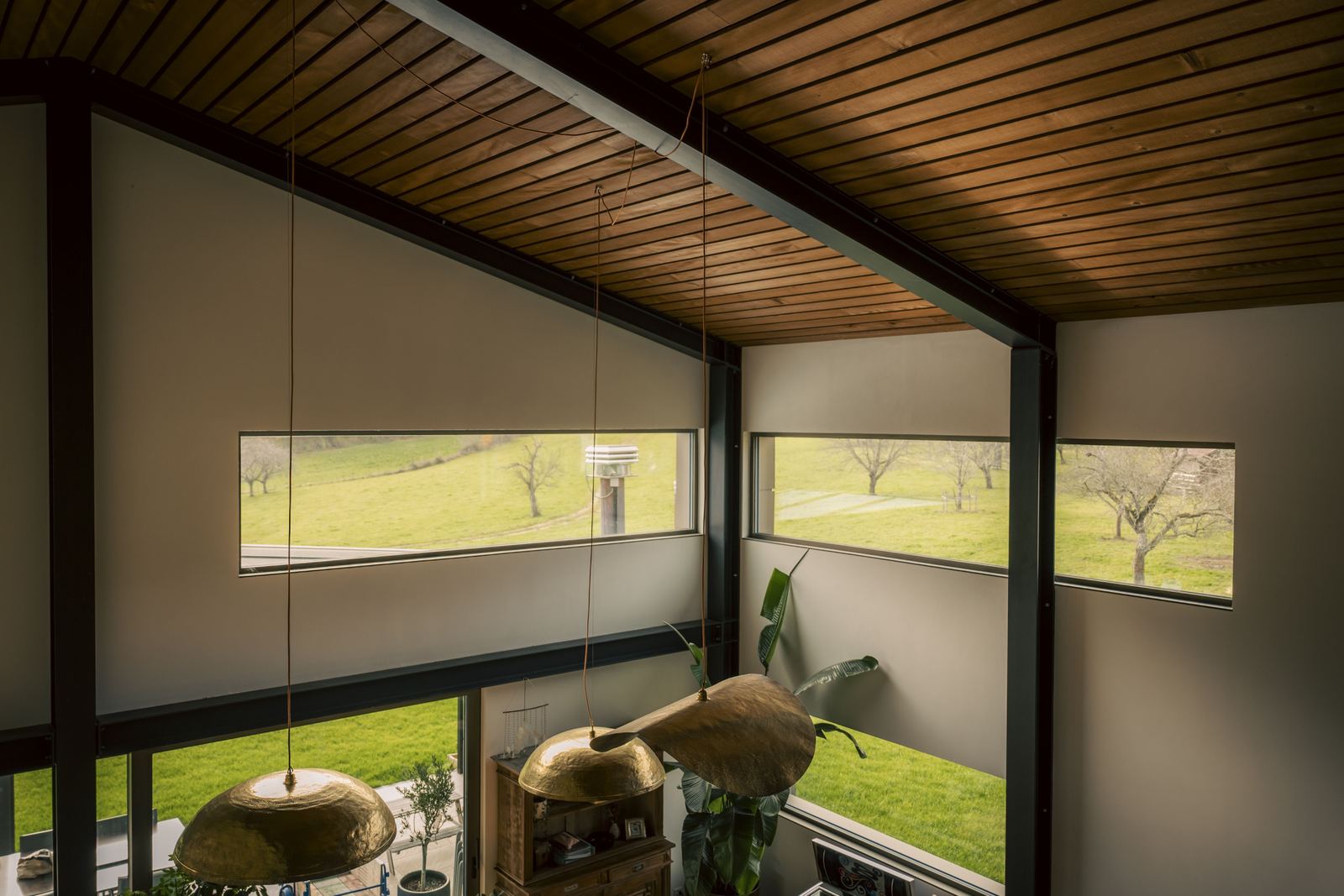 Intérieur sous toiture, grandes baies sur la campagne
